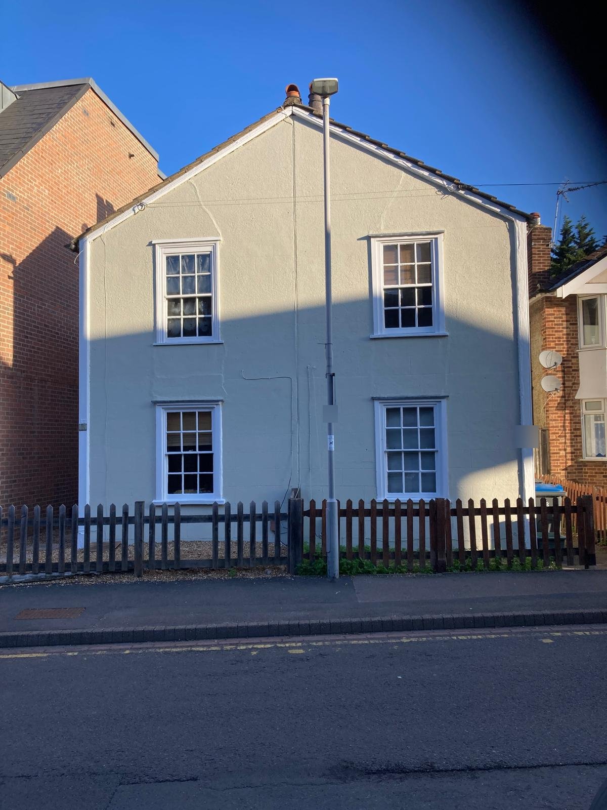The finished cottage in Kingston, repainted in a light stone colour with crisp white sash windows