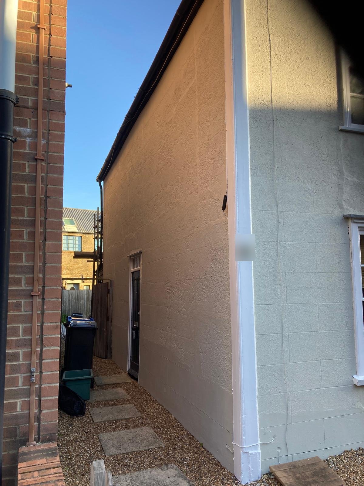 Side elevation of the cottage repainted in a light stone colour