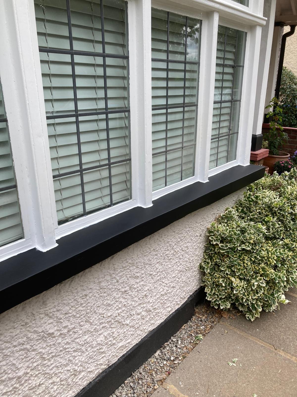 Bay window sill in East Molesey after repair, finished in black gloss with white frames