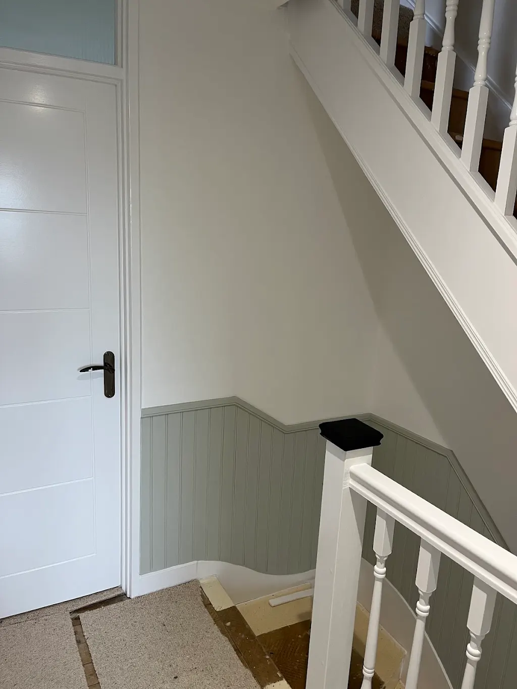Sage tongue-and-groove hallway panelling with a white door and frame in Strawberry Hill