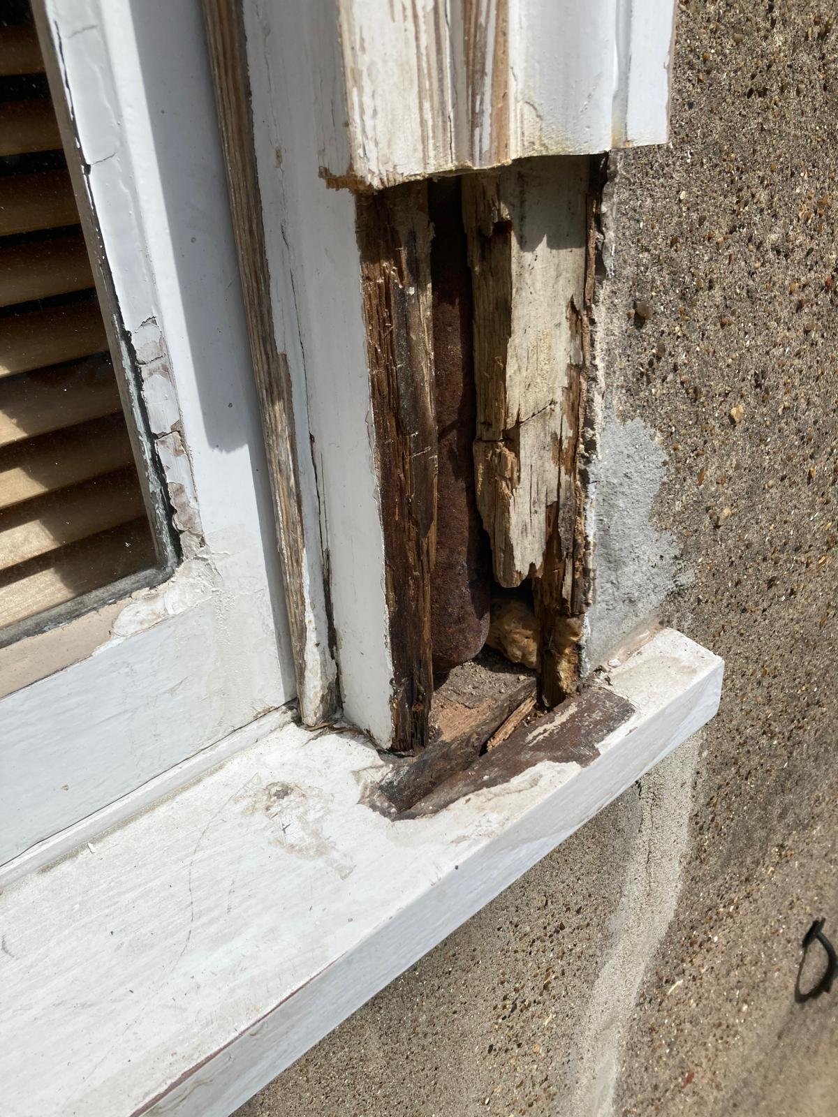 Rotten timber cut out of a sash box frame, exposing the sash weight inside