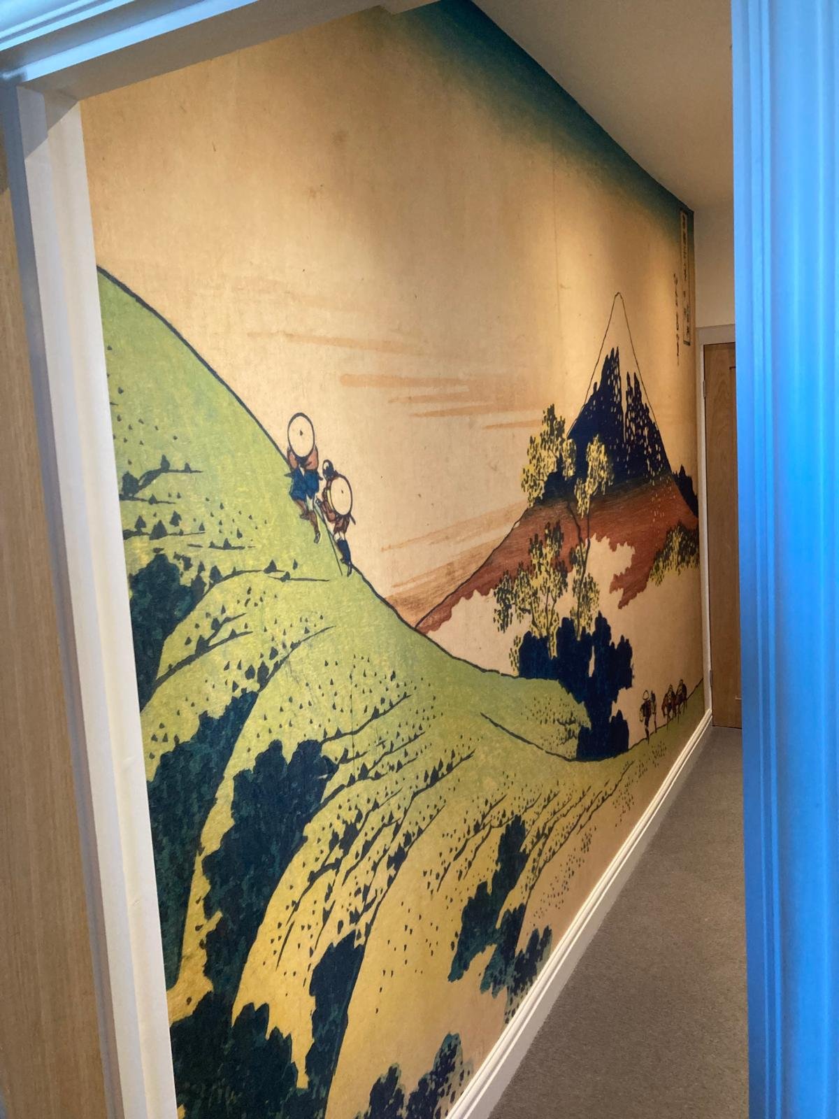 Japanese woodblock-style landscape wallpaper mural running the length of a Teddington hallway